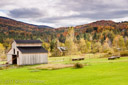 The overcast sky creates moody hills in the background but the sun shining on the foreground brings out the vivid green